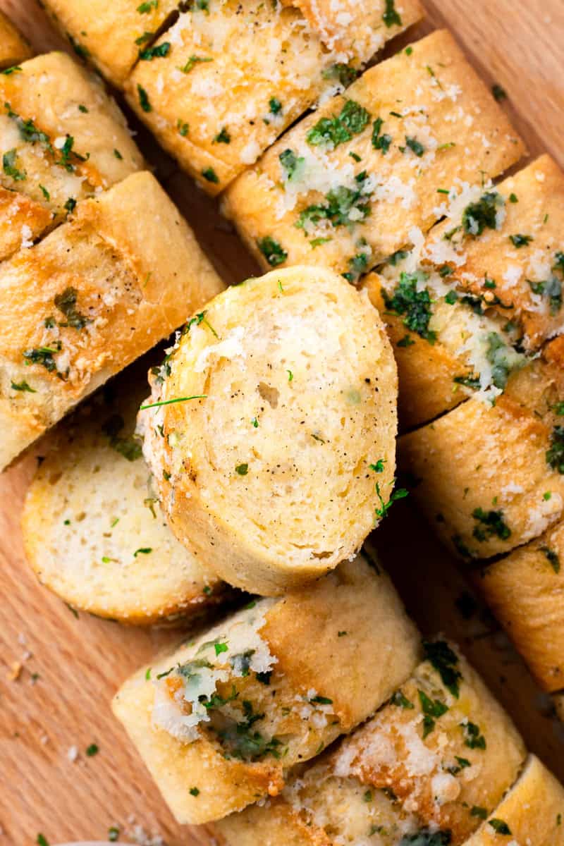 gluten free garlic bread on a tray with parmesan and parsley