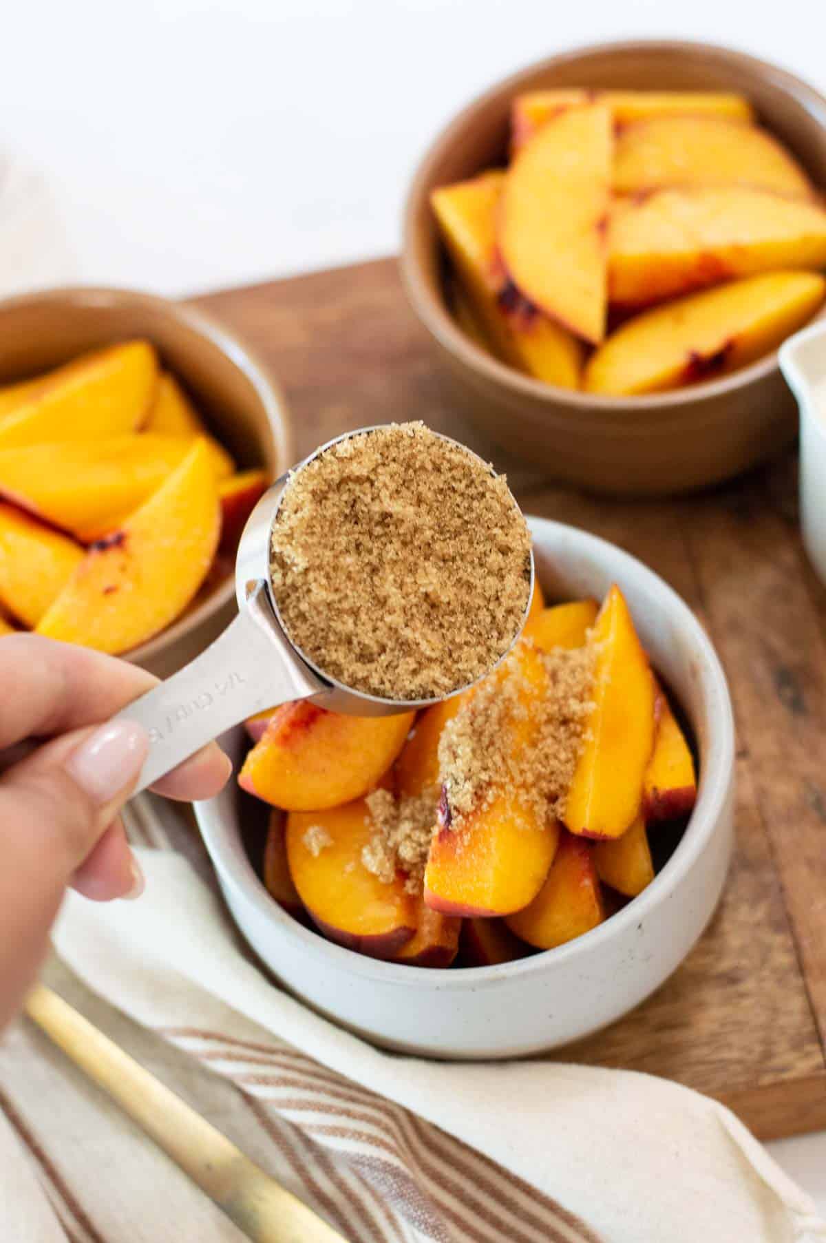 Fresh peaches in bowls with brown sugar