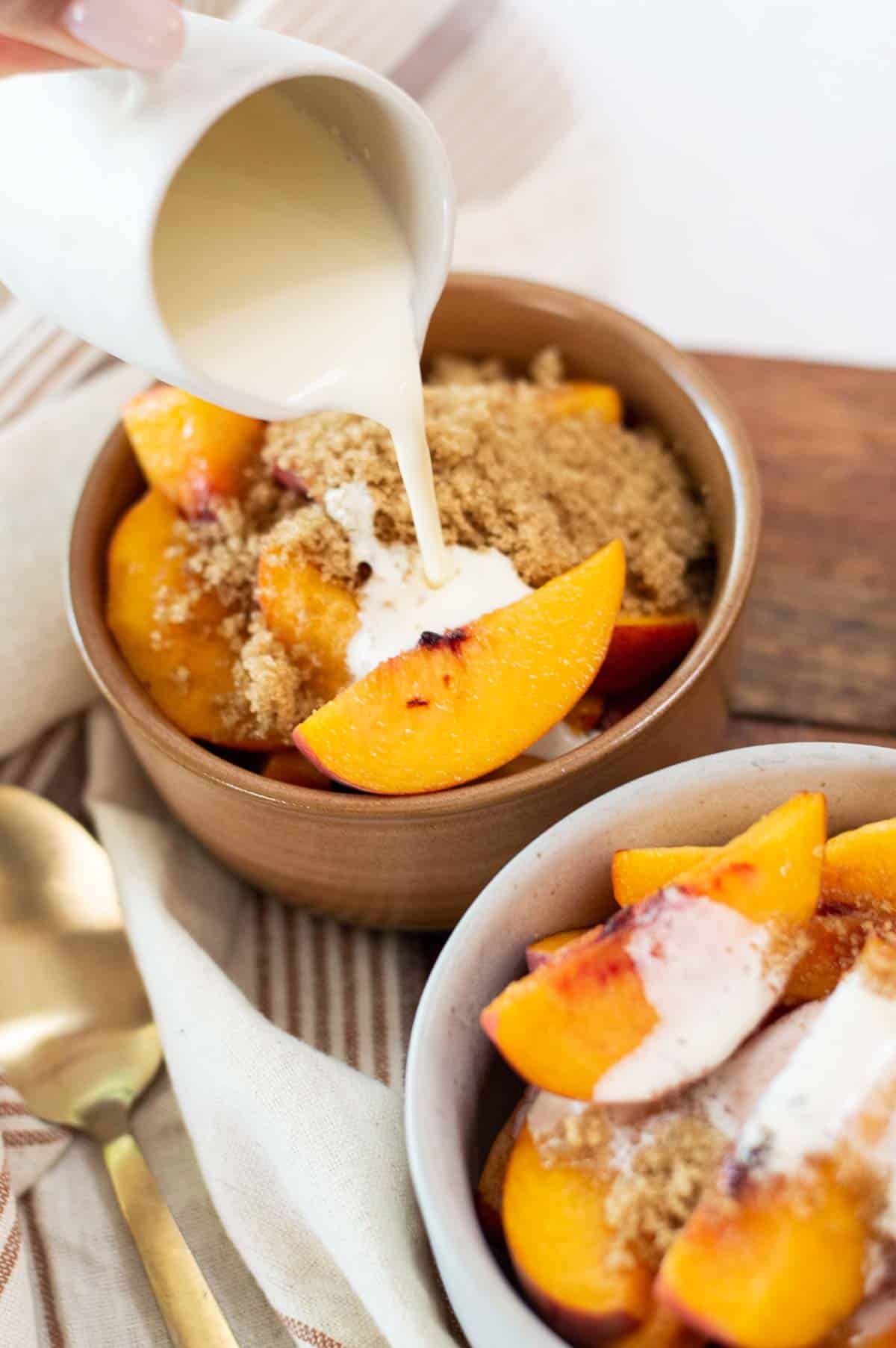 Fresh peaches in bowls pouring cream over them