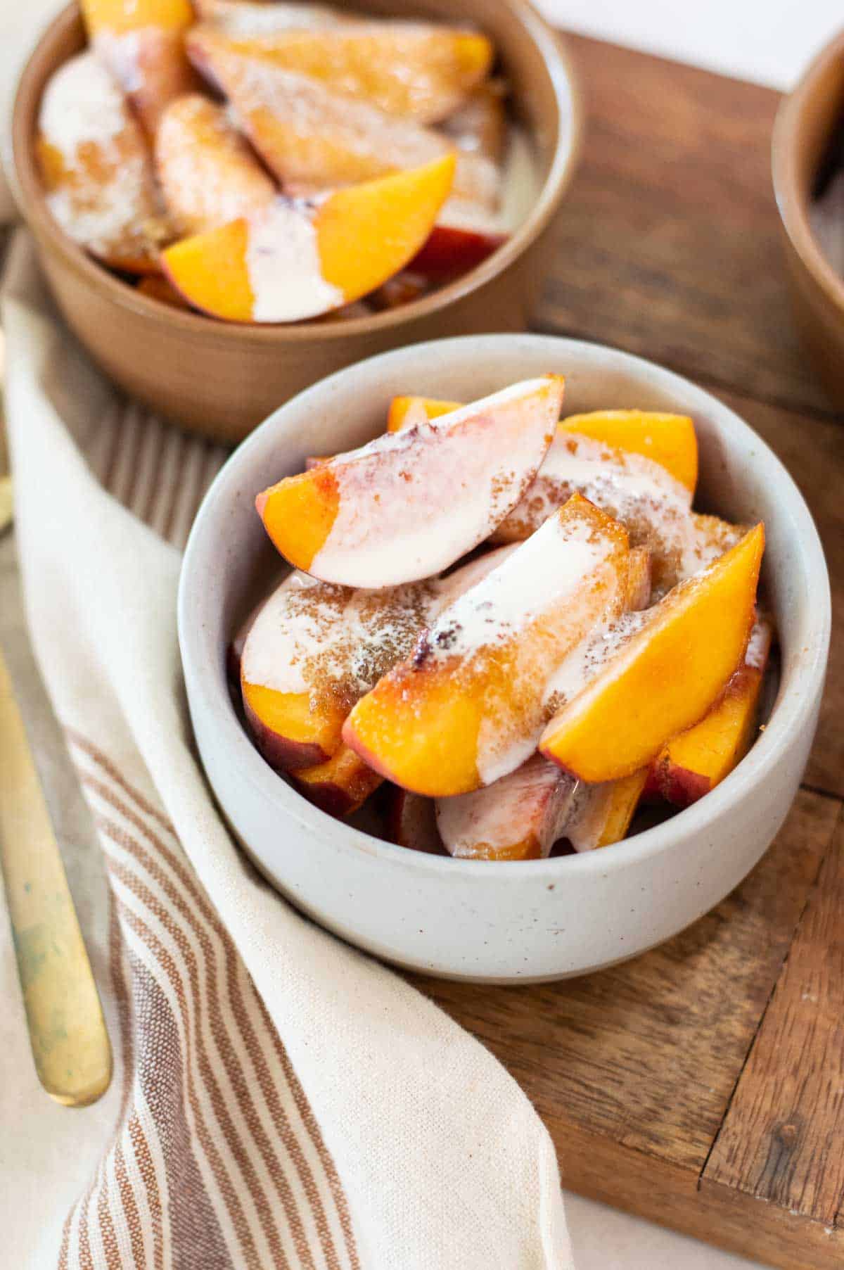 Fresh peaches in bowls with cream and sugar