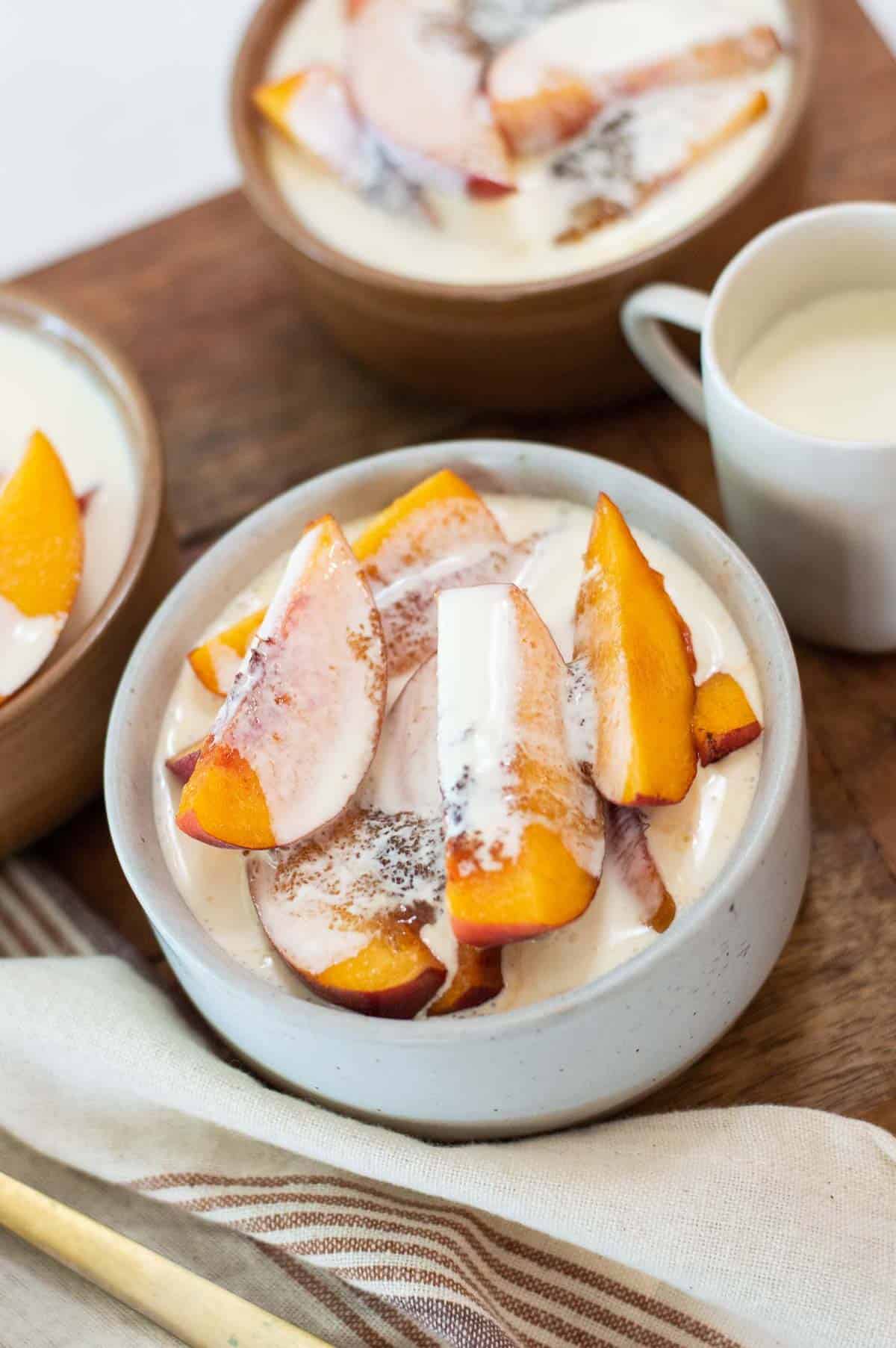 Fresh peaches in bowls with cream and sugar