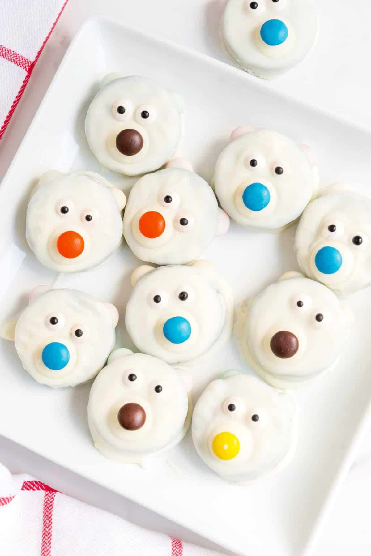 A plate full of polar bear cookies. They have different colored noses.