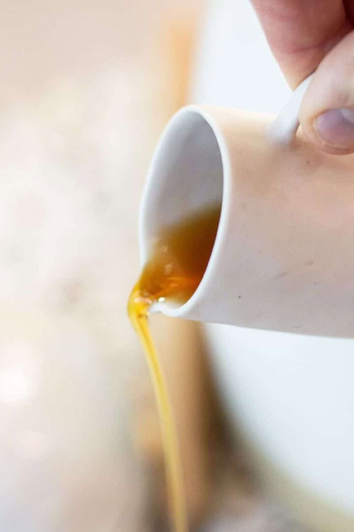 Maple syrup being poured from a cup