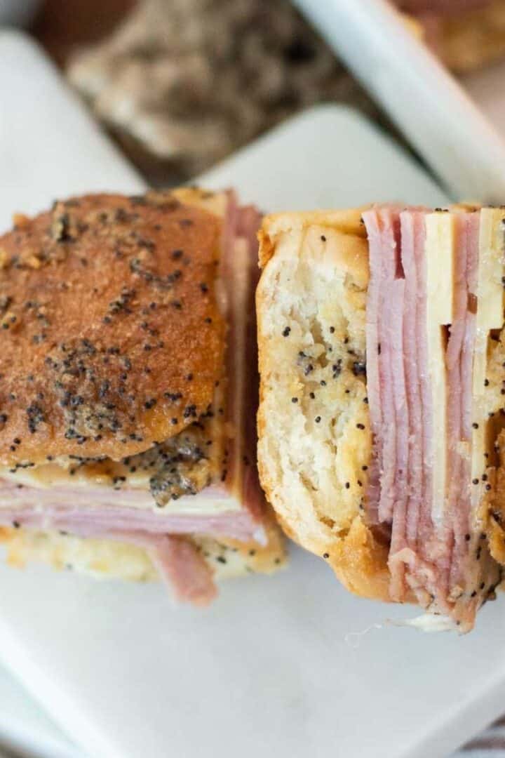 Hawaiian roll sliders one on the side on a marble plate