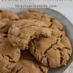 Gluten free molasses cookies on a plate with a bite taken out of the top cookies. image with title above the cookies on the plate
