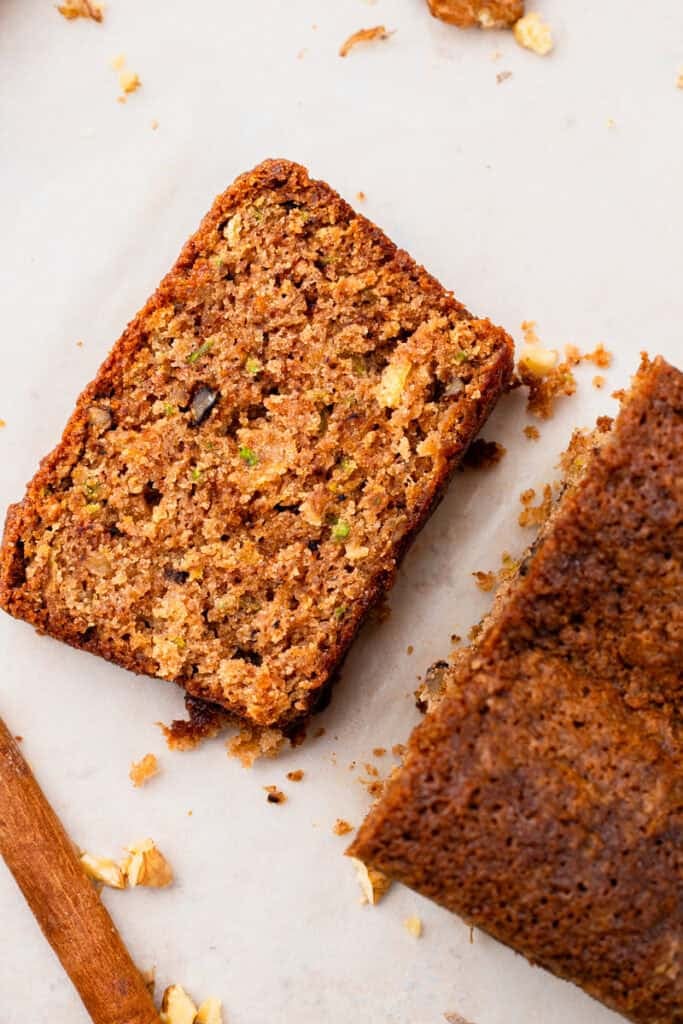 top down image of Extra Moist Gluten Free Zucchini Bread slice next to the loaf of bread
