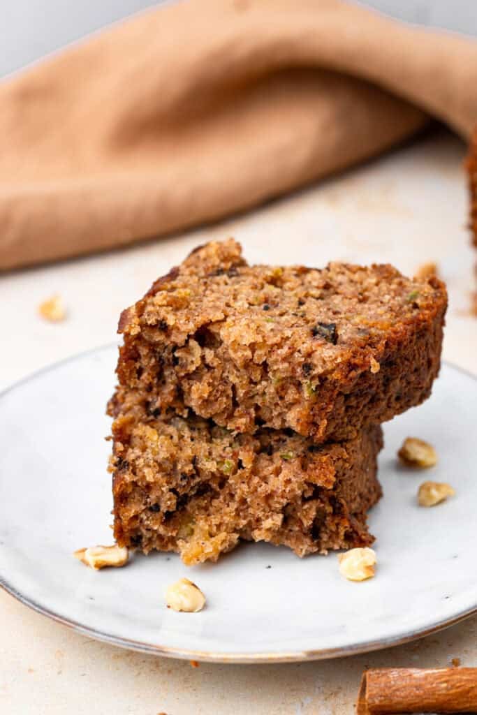 side view of slices of Extra Moist Gluten Free Zucchini Bread on a plate stacked on top of each other