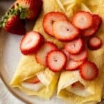 gluten free crepes on a plate with strawberries