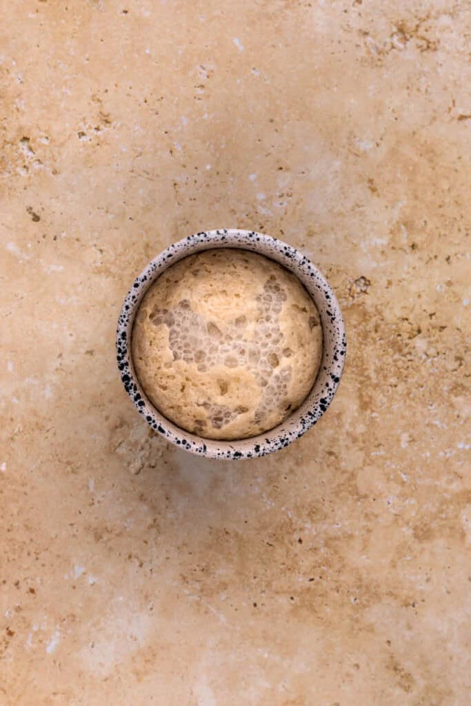 Brown sugar and butter in a bowl with cinnamon and yeast mixture in a small bowl.