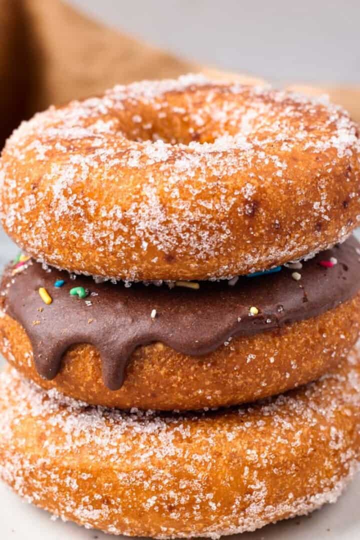 Gluten Free Donuts (Fried, Bakery Style) stacked on top of each other with chocolate frosting and sugared outsides
