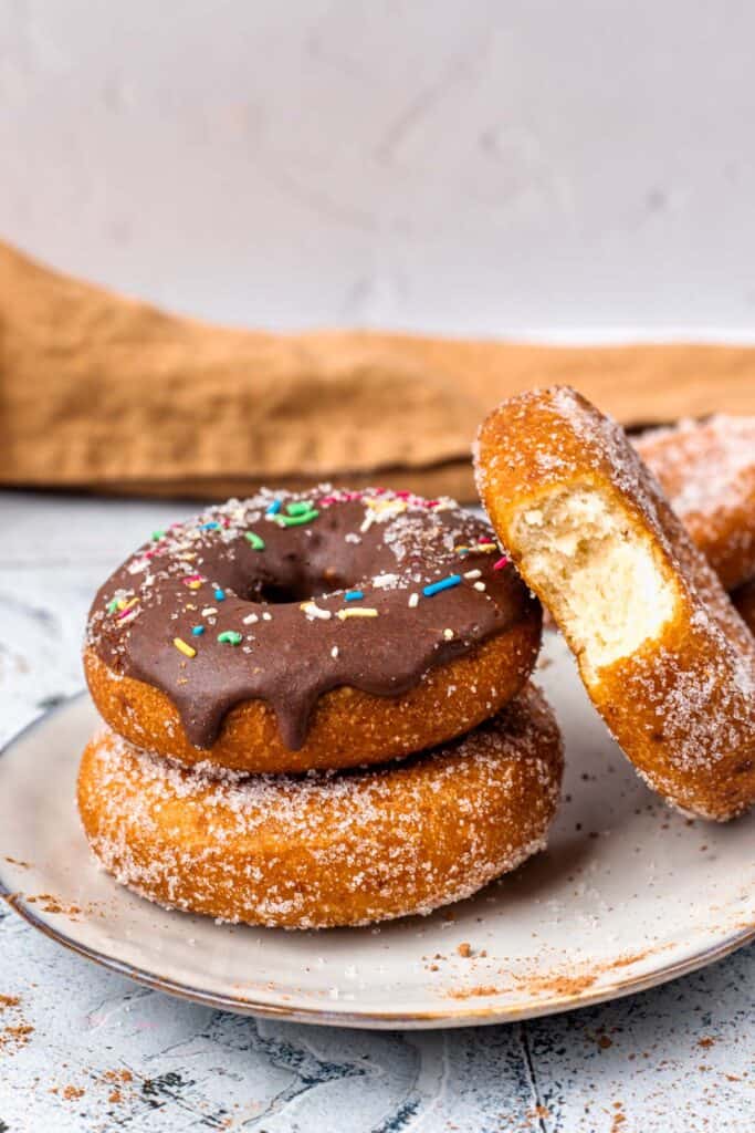 Gluten Free Donuts (Fried, Bakery Style) stacked on top of each other with chocolate frosting and sugared outsides