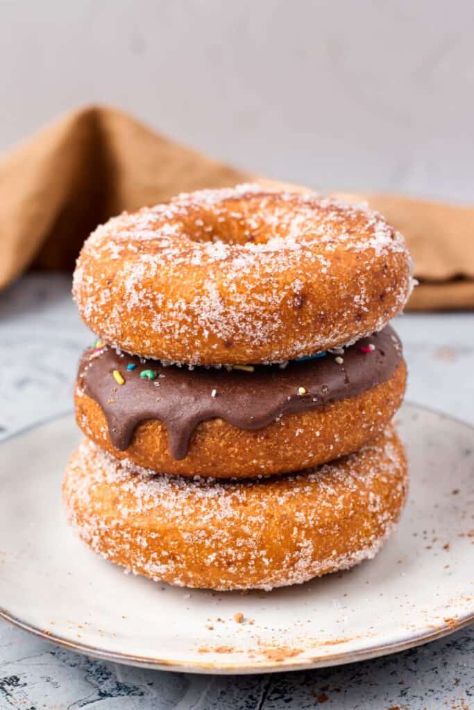 Gluten Free Donuts (Fried, Bakery Style) stacked on top of each other with chocolate frosting and sugared outsides