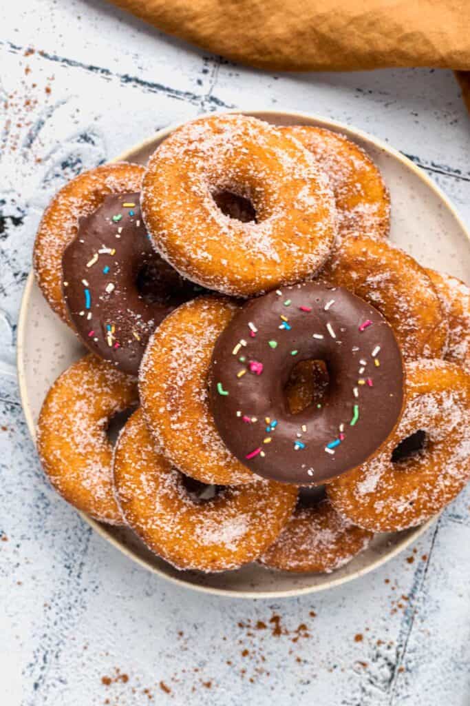 Gluten Free Donuts (Fried, Bakery Style) on a plate with chocolate frosting and sugared outsides
