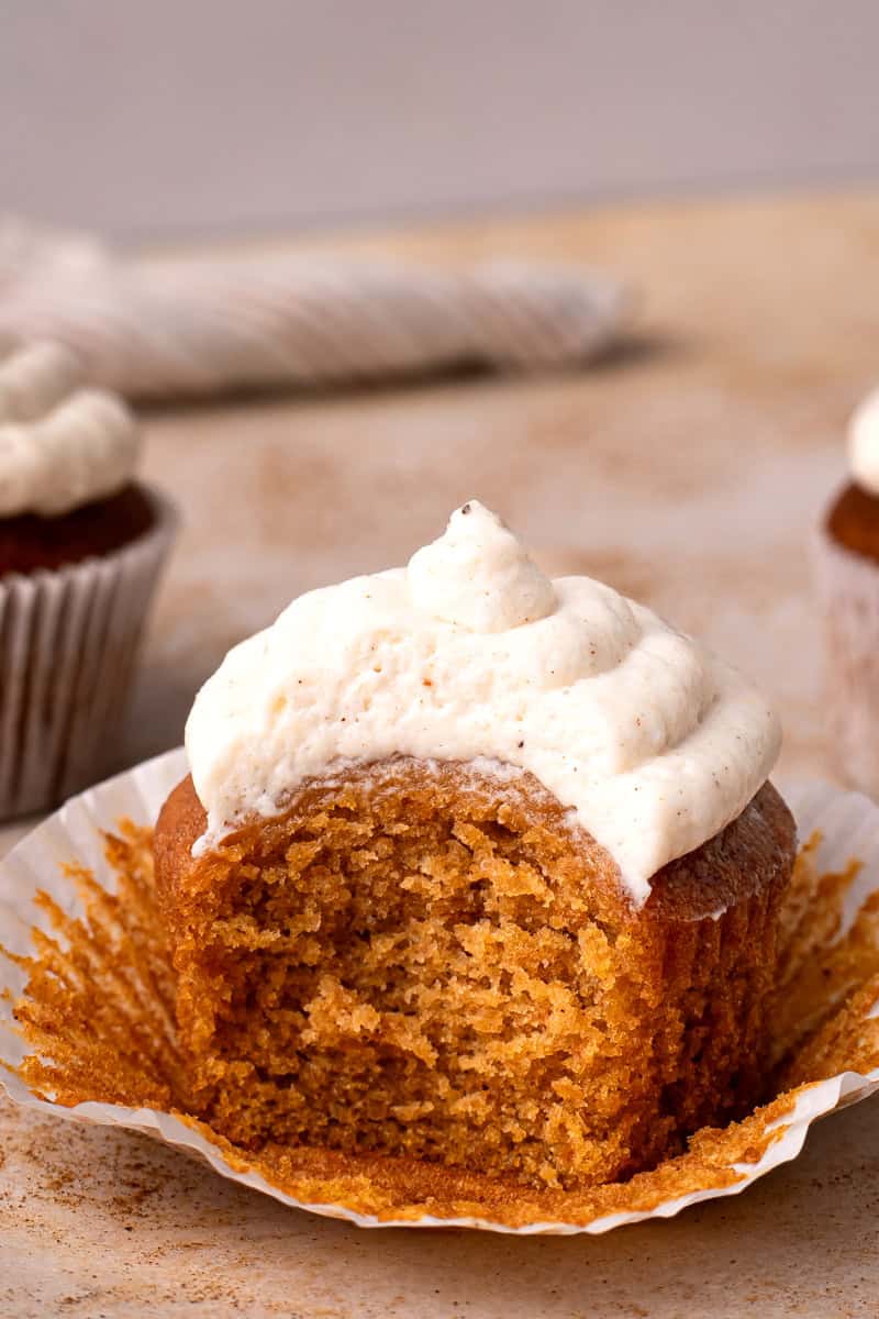 Gluten free pumpkin cupcakes with frosting and a bite taken out
