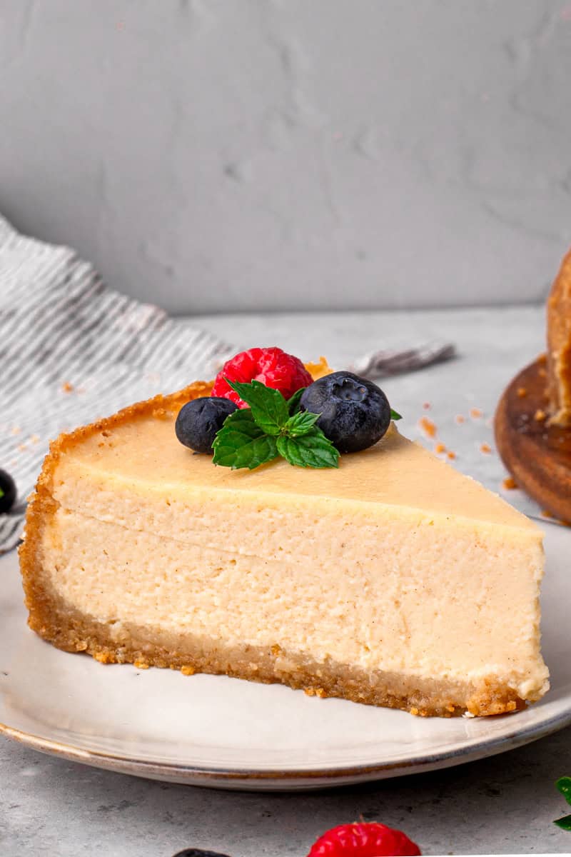 New York Style Gluten Free Cheesecake slice with berries and mint on top