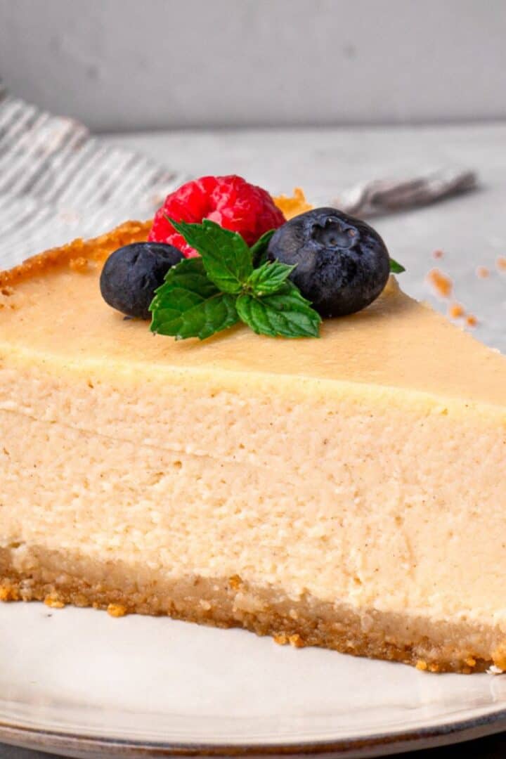 New York Style Gluten Free Cheesecake slice with berries and mint on top