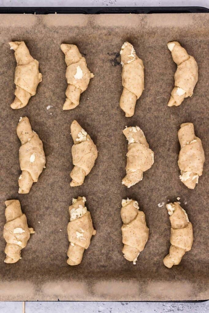 gluten free crescent roll dough with butter on a tray ready to be baked