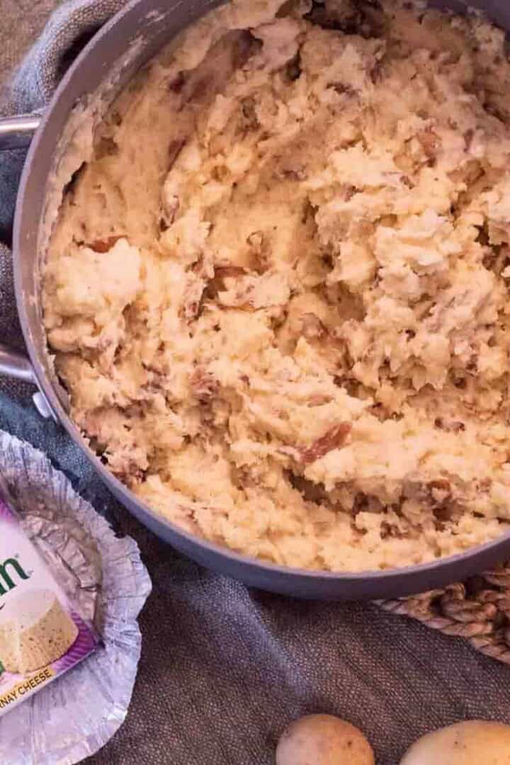 Boursin Mashed Potatoes in a pot with the cheese near it