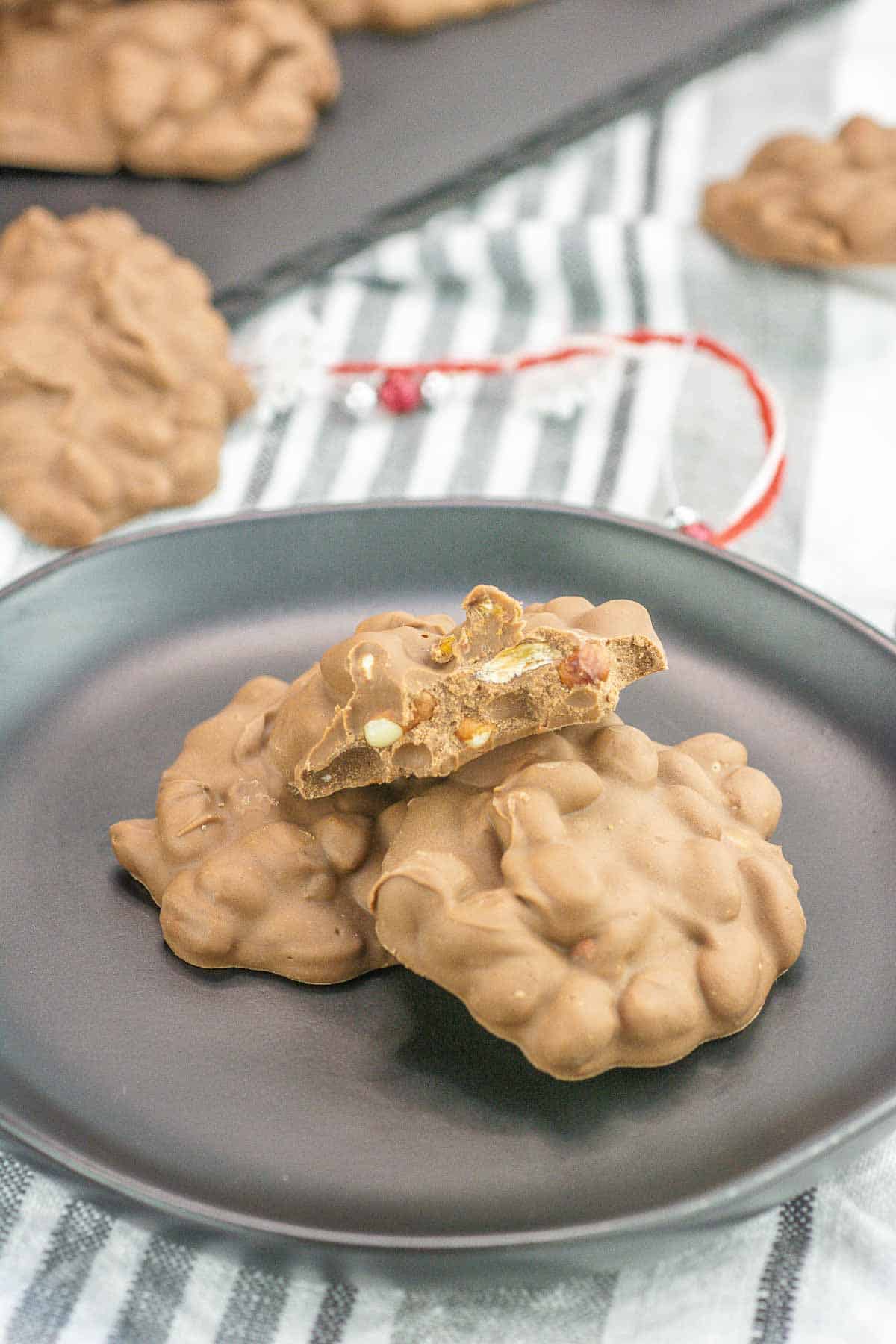 crockpot candy on a plate with a bite take out of it and peanuts showing