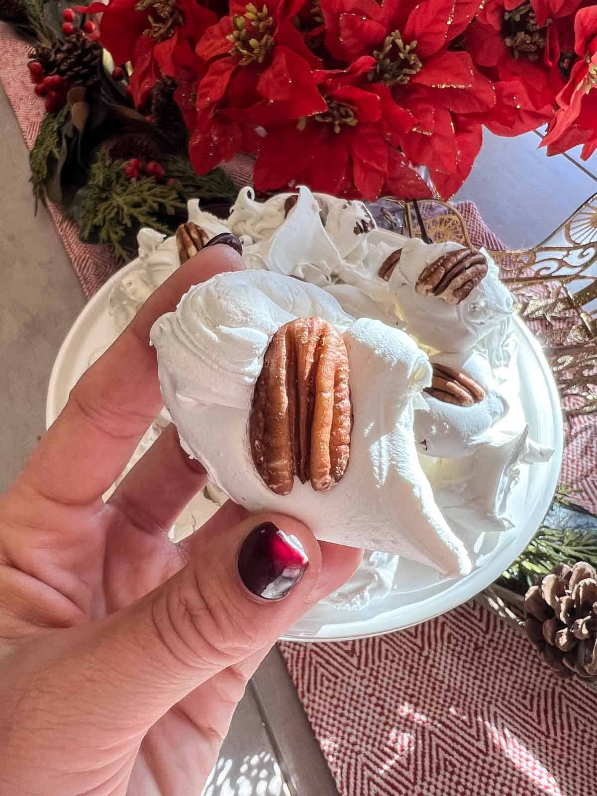 classic divinity candy in a hand with a pecan on top