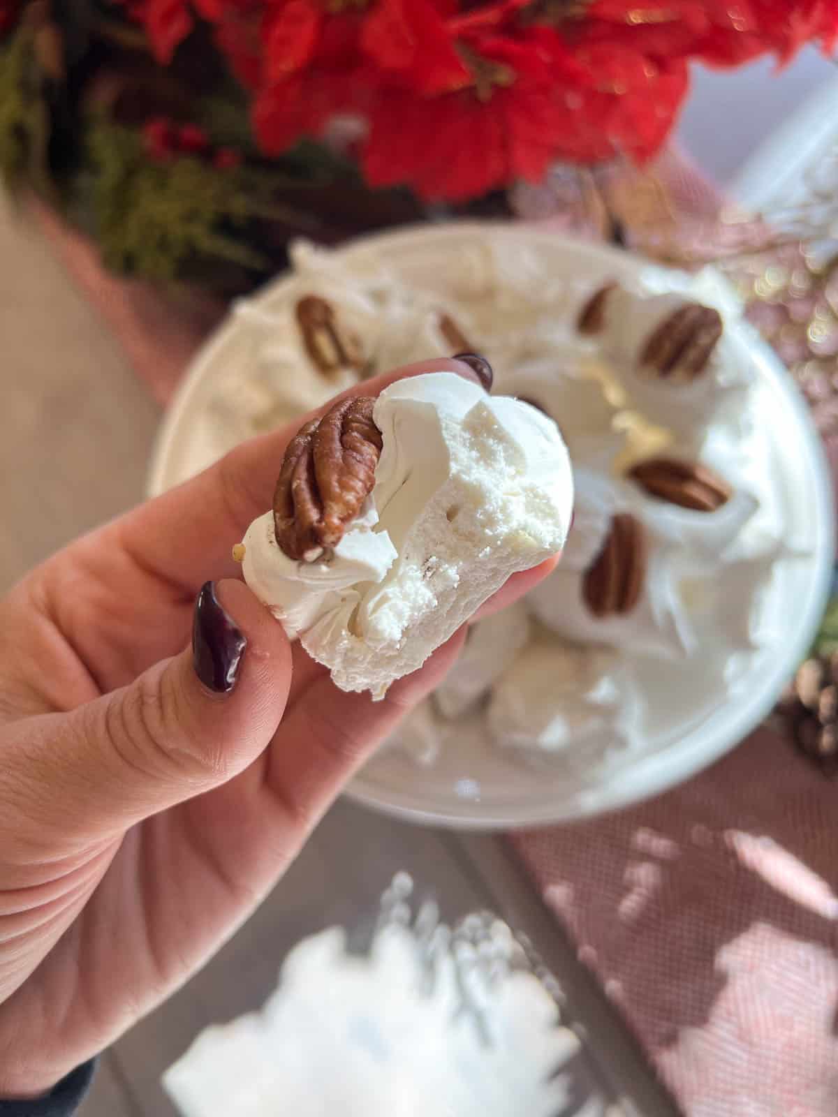 classic divinity candy in a hand with a pecan on top
