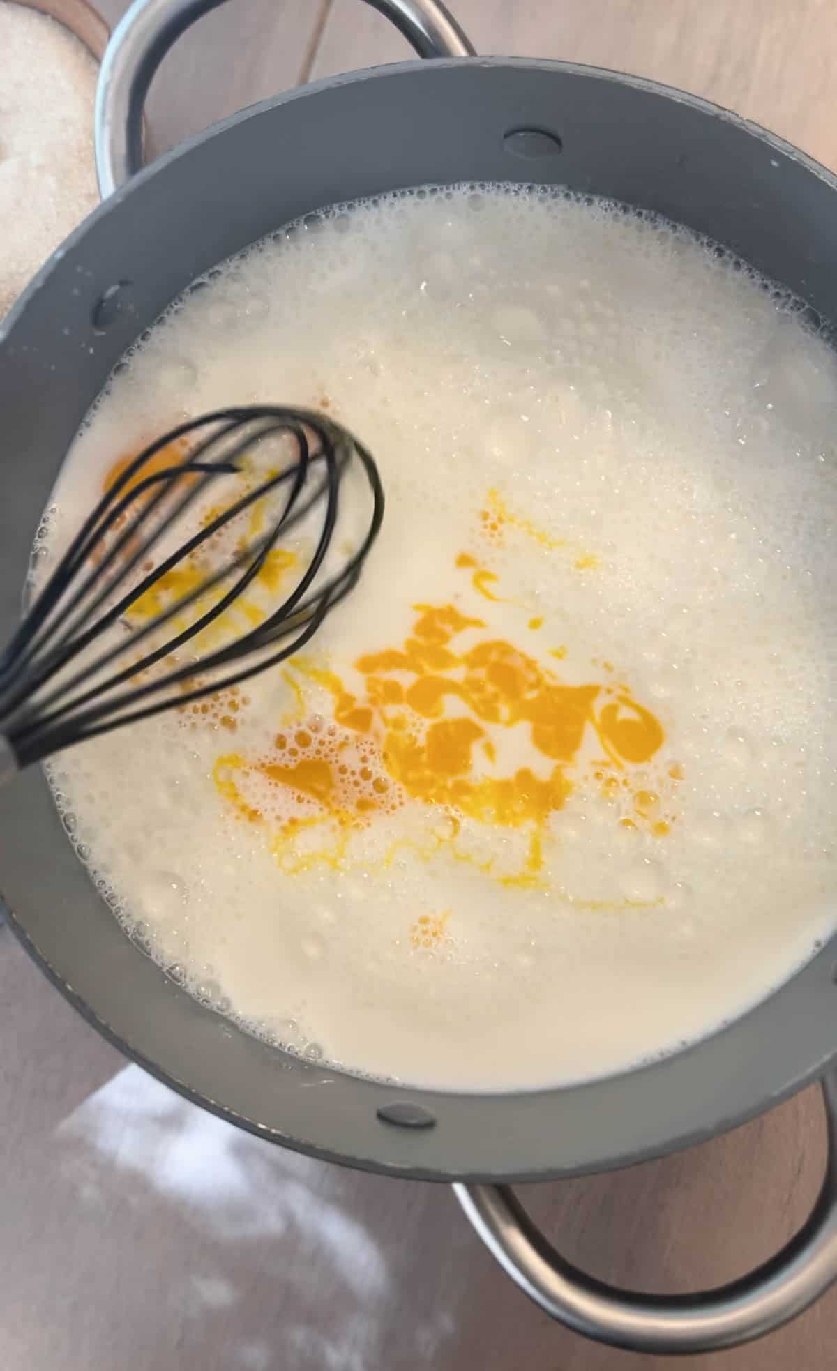 Non Alcoholic Eggnog Recipe being made with milk and eggs being stirred