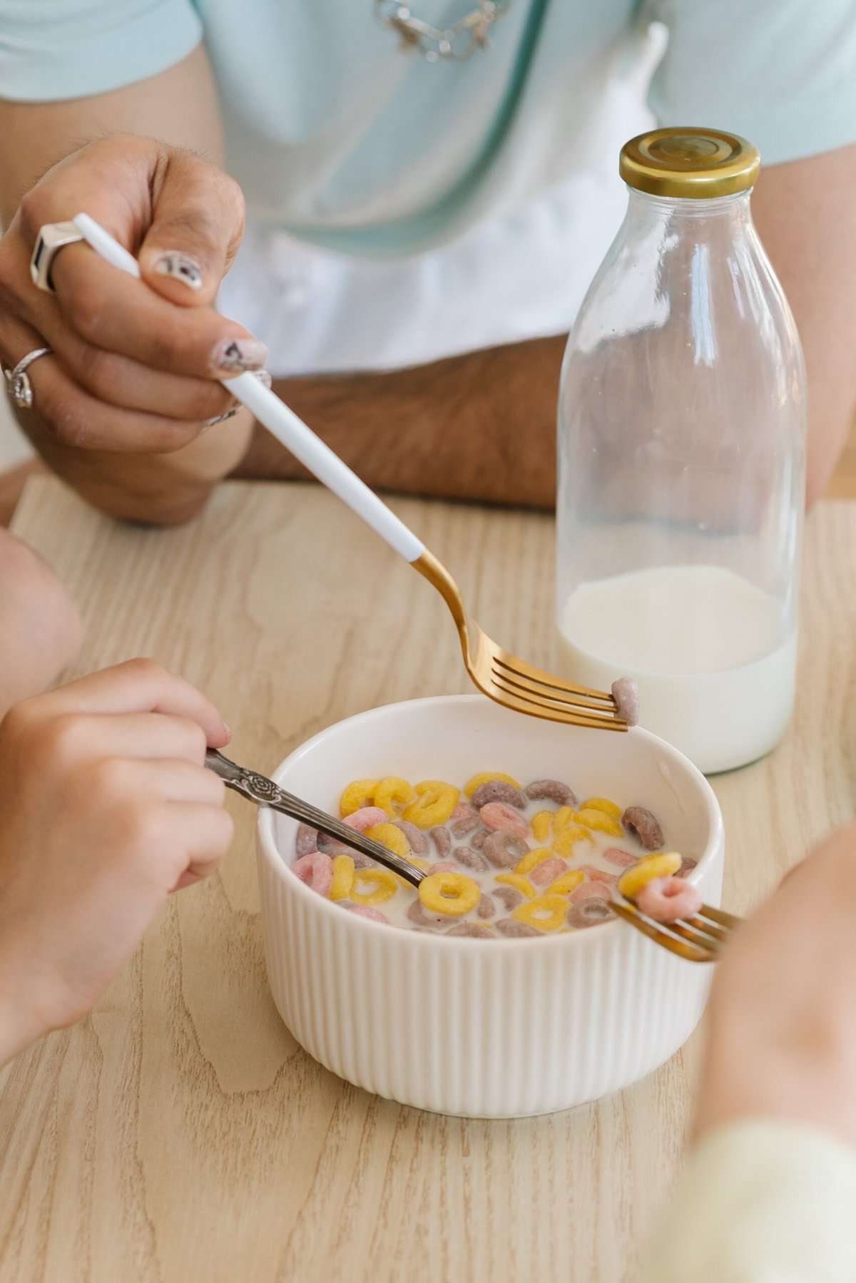 Gluten Free Cereal in a white bowl with two spoons and milk