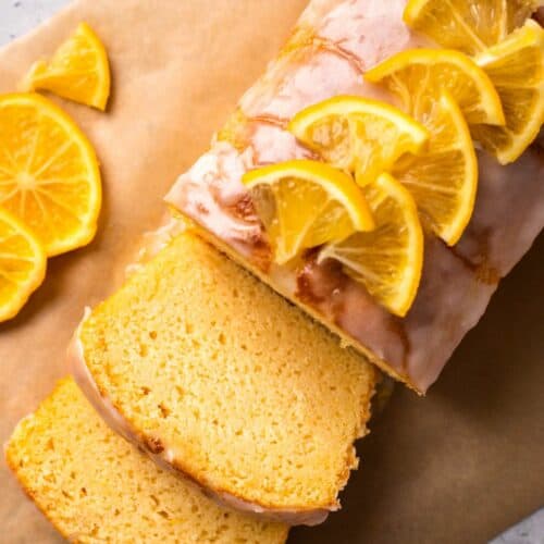 Gluten Free Lemon Drizzle Cake sliced with glaze and cut lemons on top
