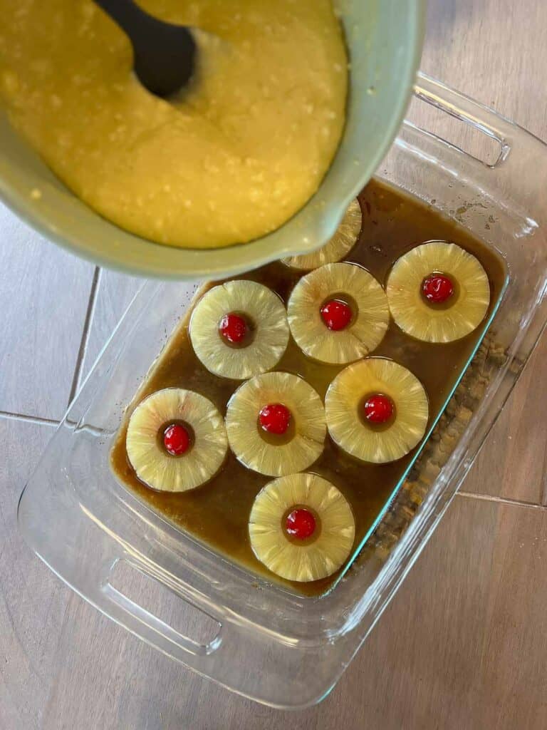 Gluten free pineapple upside down cake being made by cake batter being poured into pan