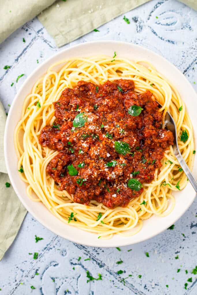 top down image of gluten free noodles in a bowl with red sauce on top and a fork in the bowl