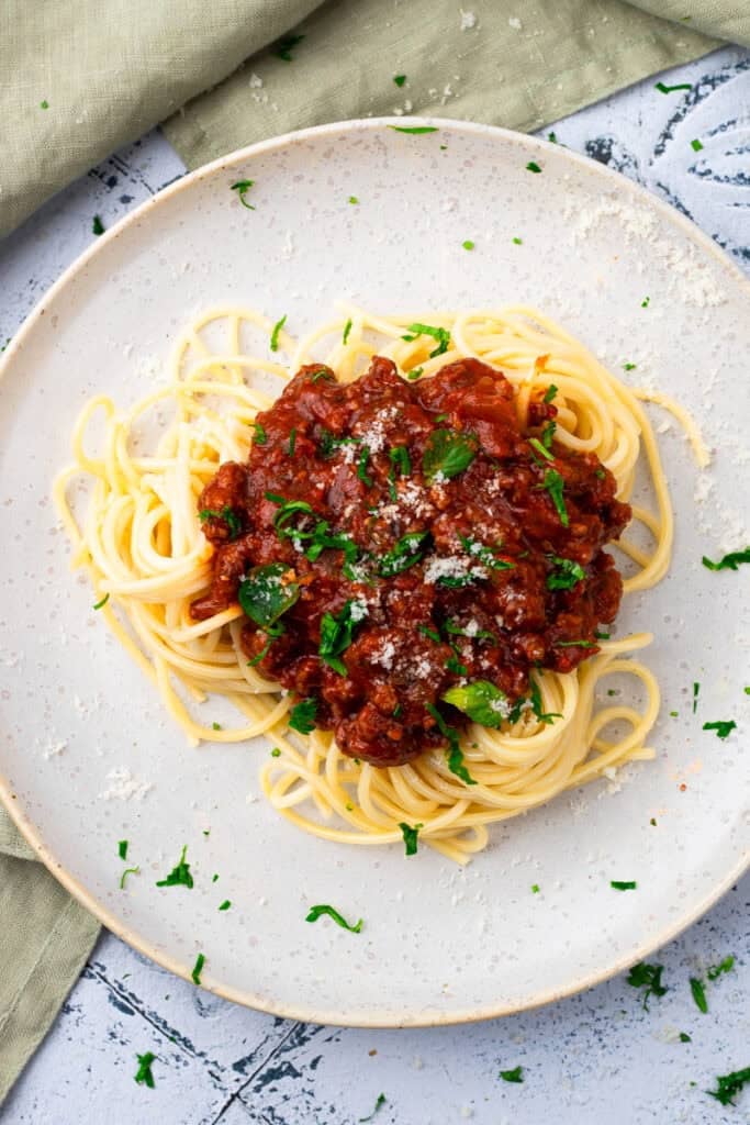 top down image of gluten free spaghetti noodles on a white plate with red sauce