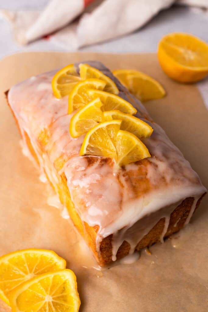 Gluten Free Lemon Drizzle Cake with sliced lemons and glaze on top