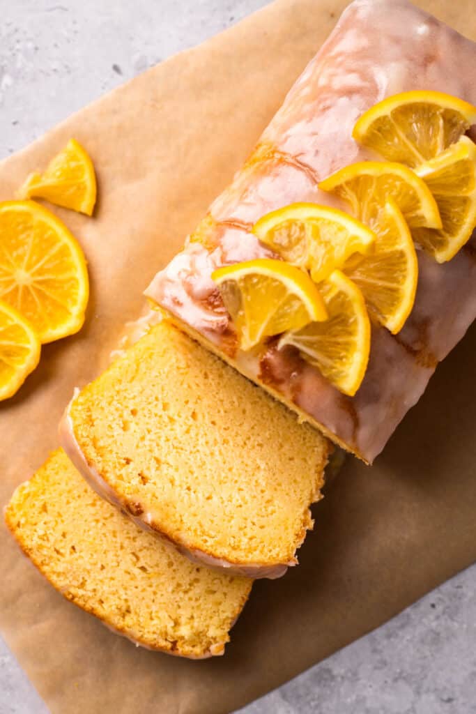 Gluten Free Lemon Drizzle Cake with sliced lemons and glaze on top