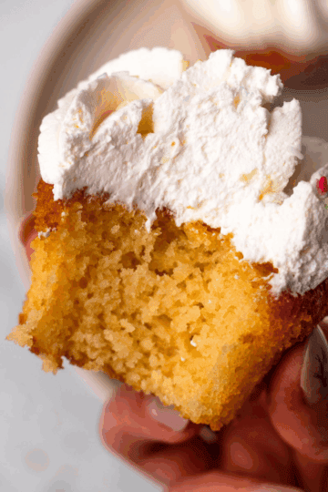 Gluten Free cupcake with bite taken out of it being held in hand