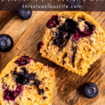 top down image of gluten free blueberry muffin split in half to show texture on a wooden cutting board.
