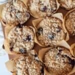 Fluffy 25-Minute Gluten Free Blueberry Muffins (with Crumb Topping) in a pan with paper liners