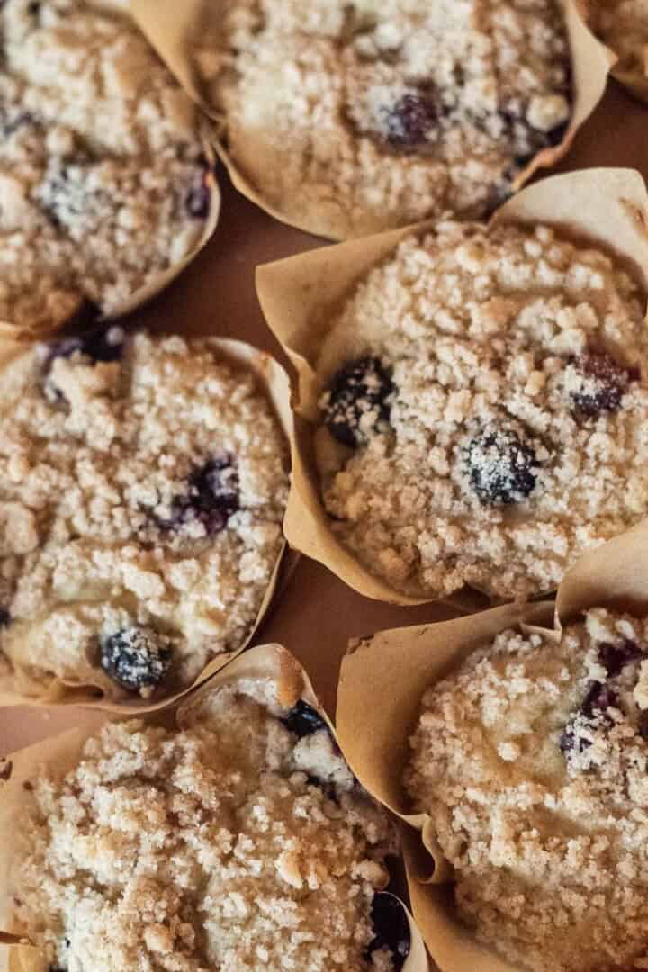 Fluffy 25-Minute Gluten Free Blueberry Muffins (with Crumb Topping) in a pan with paper liners