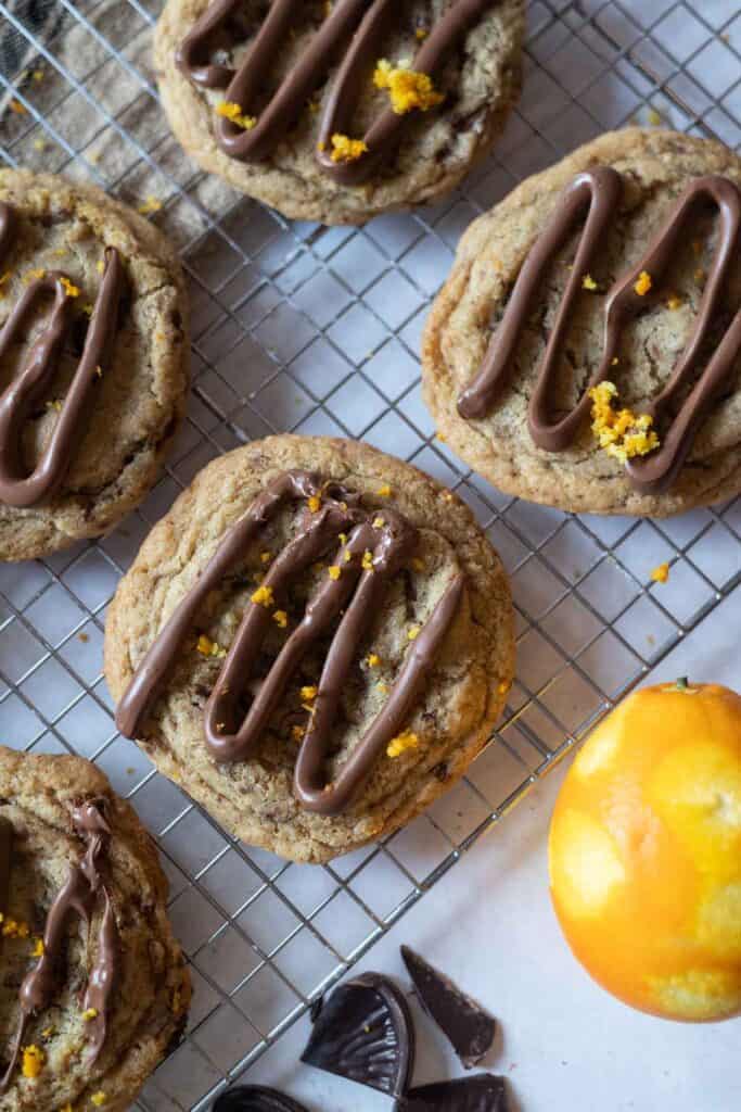 Terry's chocolate orange cookies on a wire rack with orange zest
