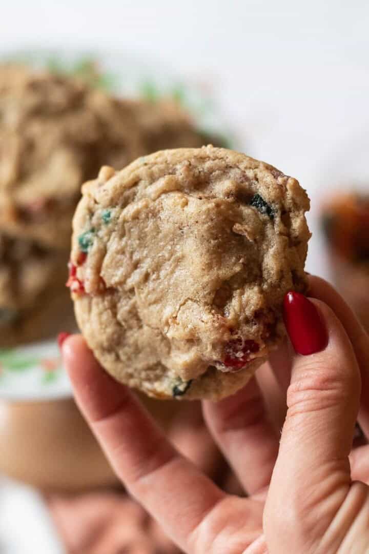 Hand with red-painted fingernails holding a cookie.