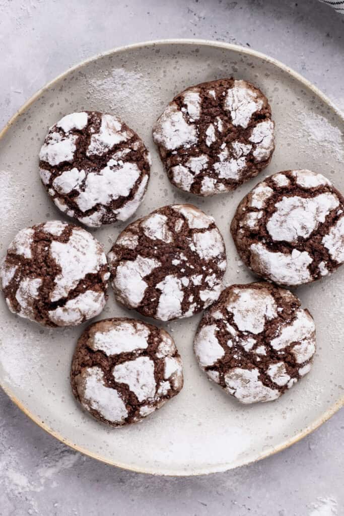 Gluten free chocolate crinkle cookies on a plate in a circle from a top view