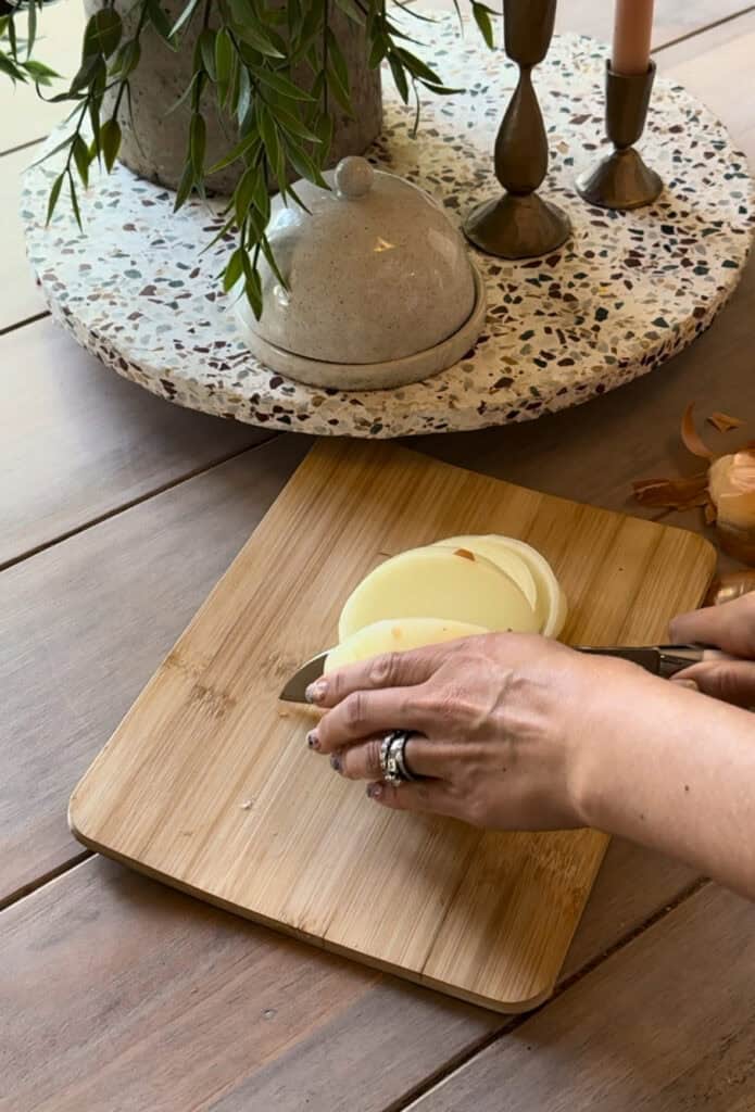 onions being cut on a wood cutting board