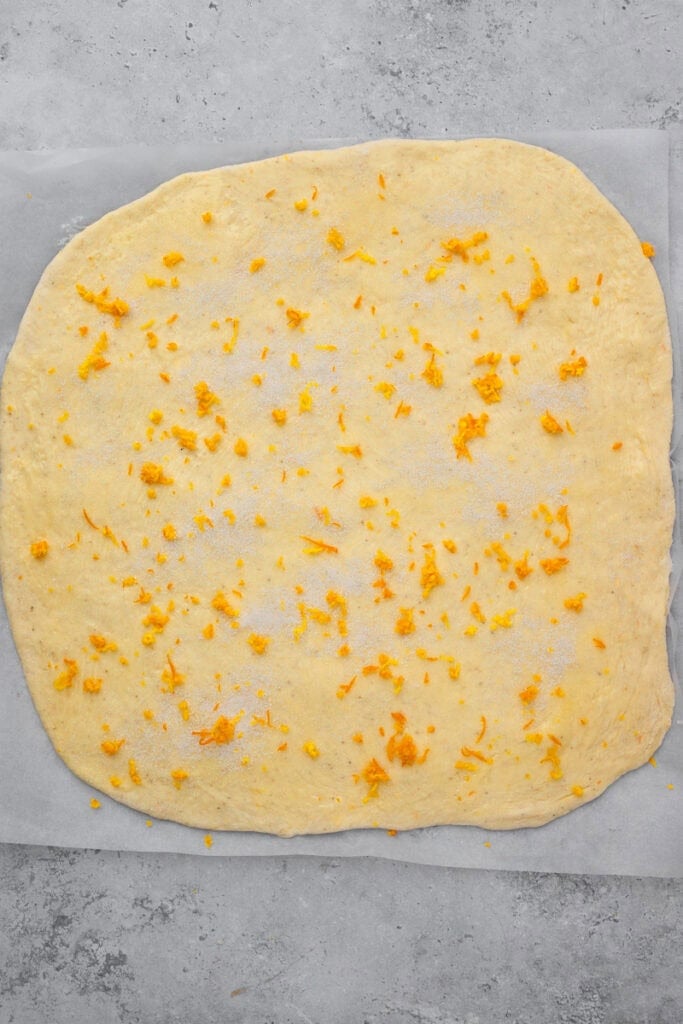dough in a rectangle with butter, sugar and orange zest