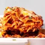 Homemade Gluten Free Lasagna piece on a spatula coming out of the pan