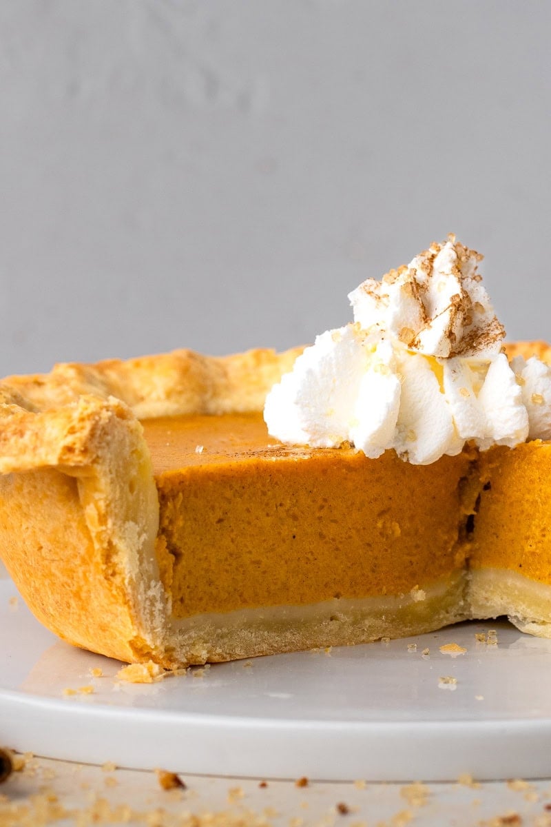 Grandma's Gluten Free Pumpkin Pie slice with a bite taken out and whipped cream on top.