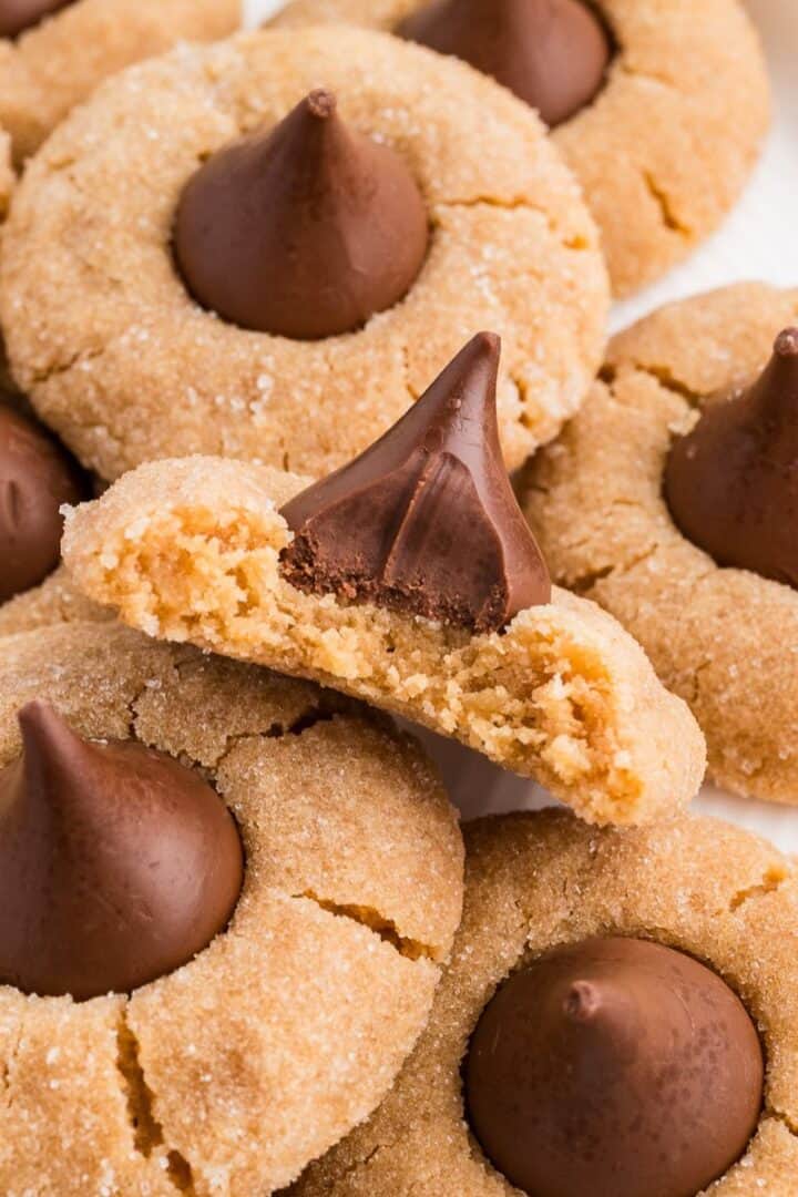 Easy Gluten Free Peanut Butter Blossoms (Dairy Free Option Too!) on a plate with a bite taken out