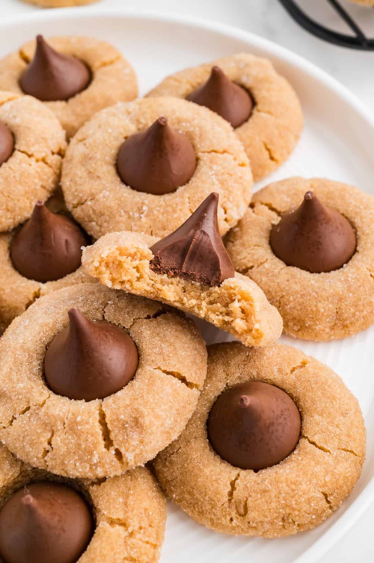 Easy Gluten Free Peanut Butter Blossoms (Dairy Free Option Too!) on a plate with a bite taken out
