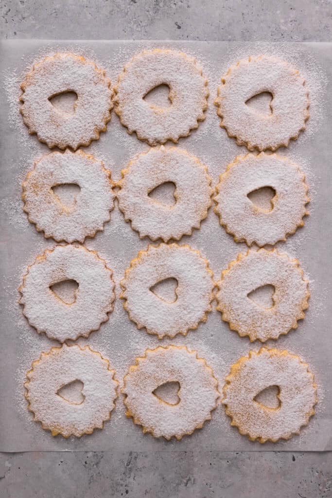 Easy Gluten Free Linzer Cookies with heart cut out and powdered sugar on top but not sandwiched yet