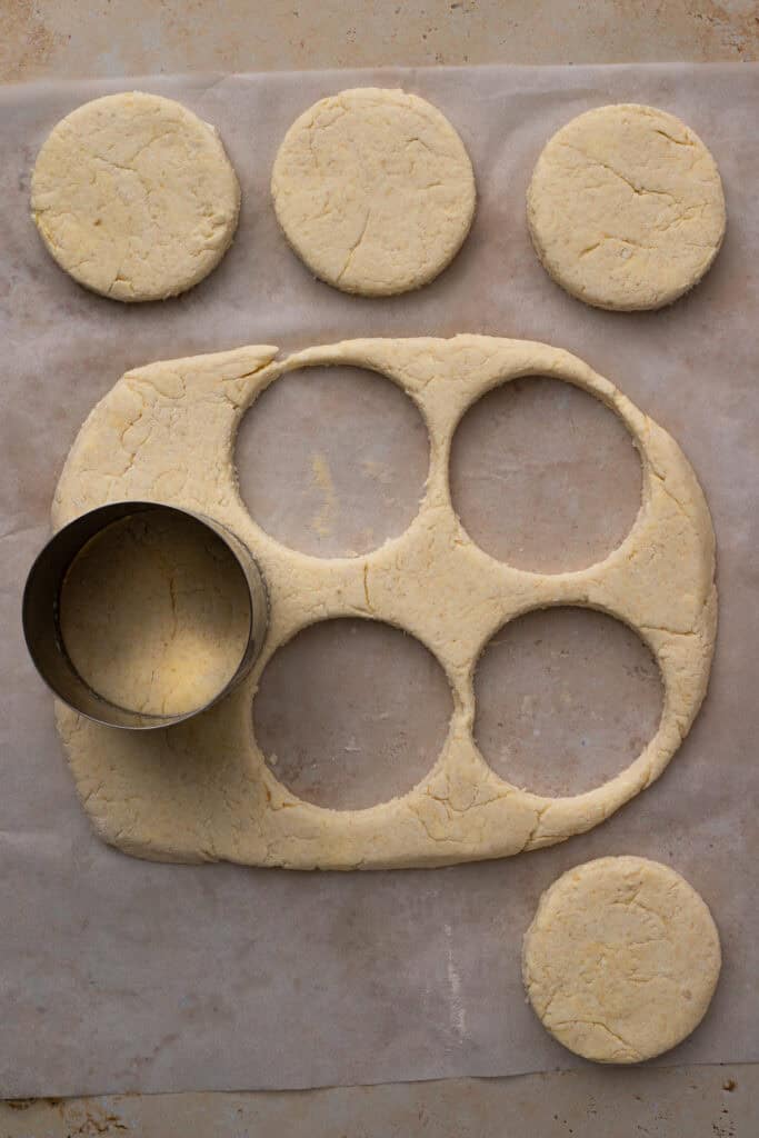 gluten free buttermilk biscuit dough being cut with a circle cutter