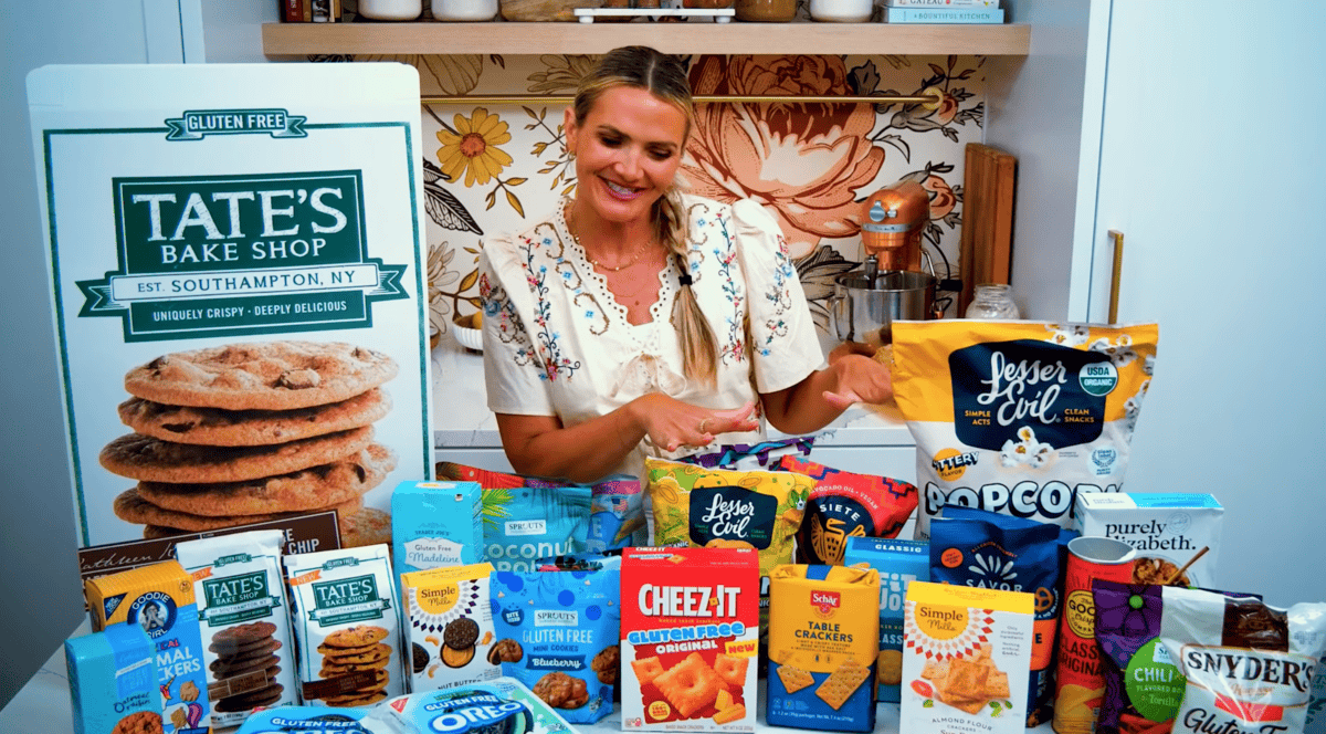 25+ gluten free snacks on a counter with a girl looking at them